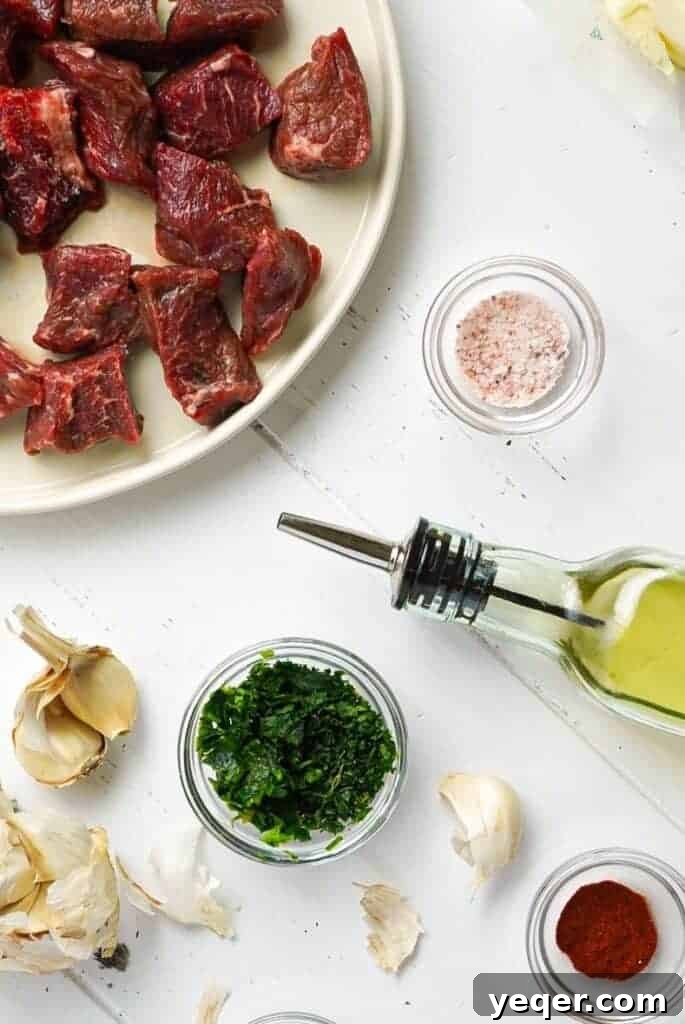 Sizzling Garlic Herb Steak Bites 3 All the fresh ingredients for Garlic Herb Steak Bites laid out on a cutting board, including steak, garlic, and fresh herbs.