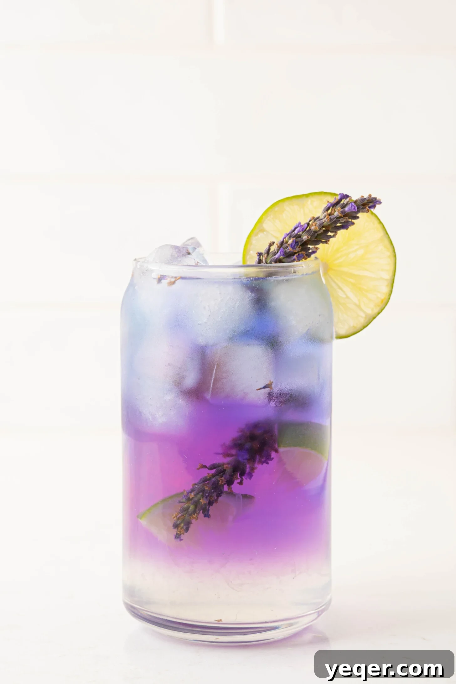 Indigo Bloom Delight 7 A finished butterfly pea flower cocktail, displaying a beautiful gradient of purple and pink, garnished with citrus.