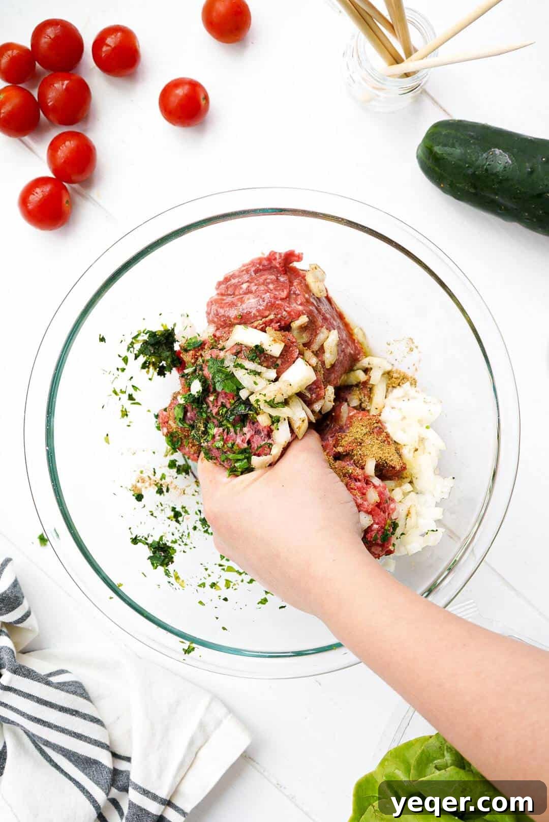 Moroccan Kefta Salad Bowl 4 A hand reaching into a bowl of ground beef and ingredients for Moroccan kefta.