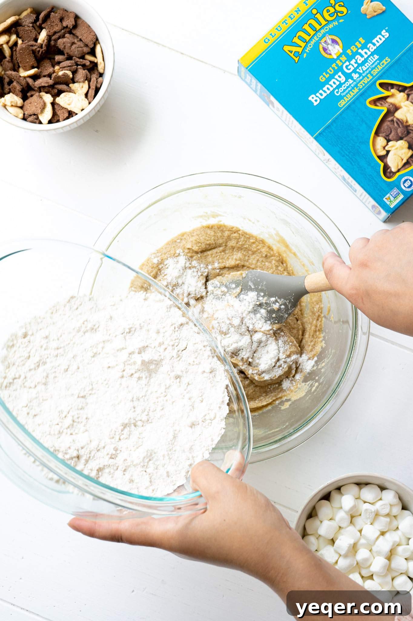 Gluten Free Smores Cookies with Annies and The Feed Feed 6 A hand pouring flour into a mixing bowl with butter, sugar, eggs and vanilla.