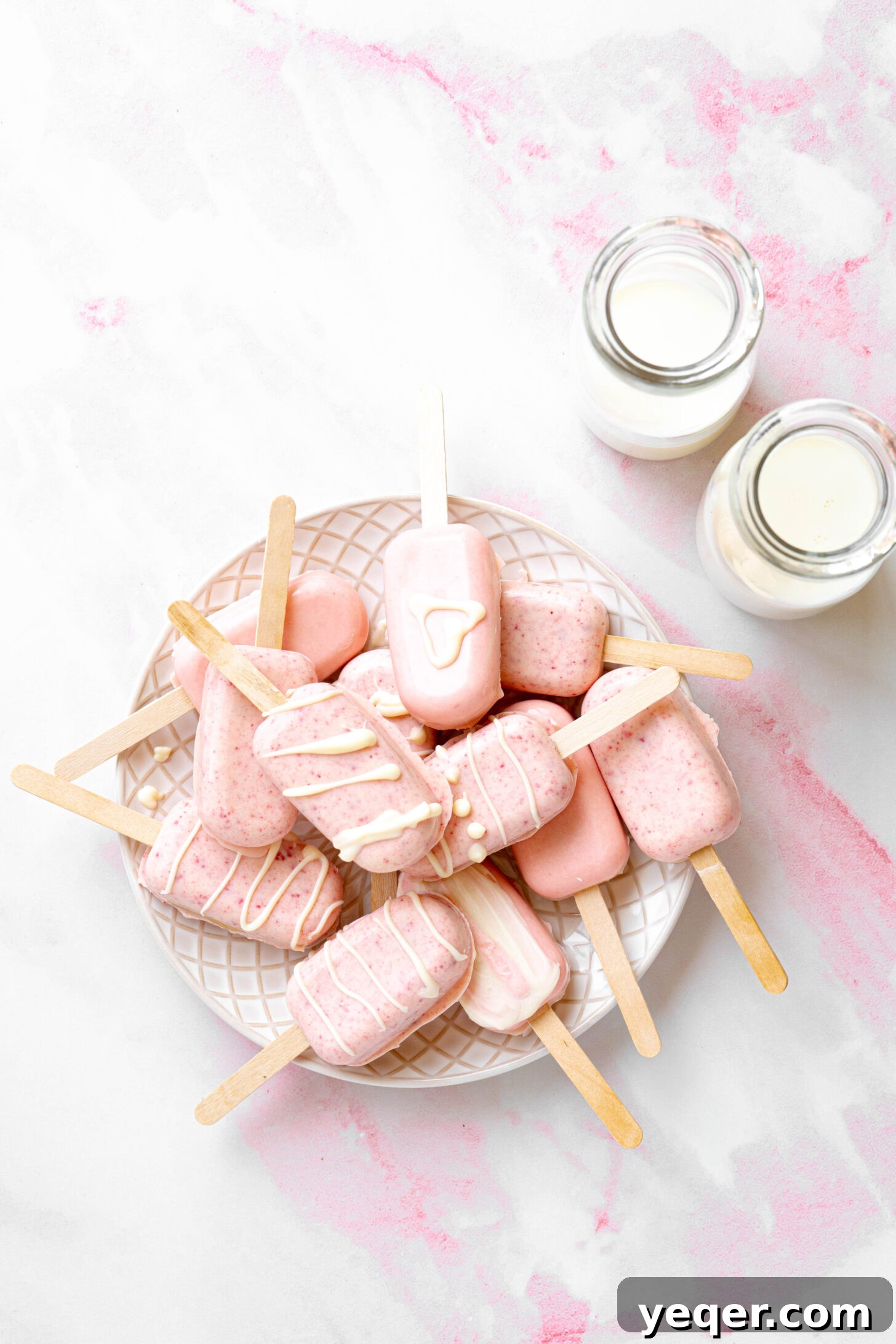 Whimsical Pink Pops 2 A plate of pink cake pops next to glasses of milk.