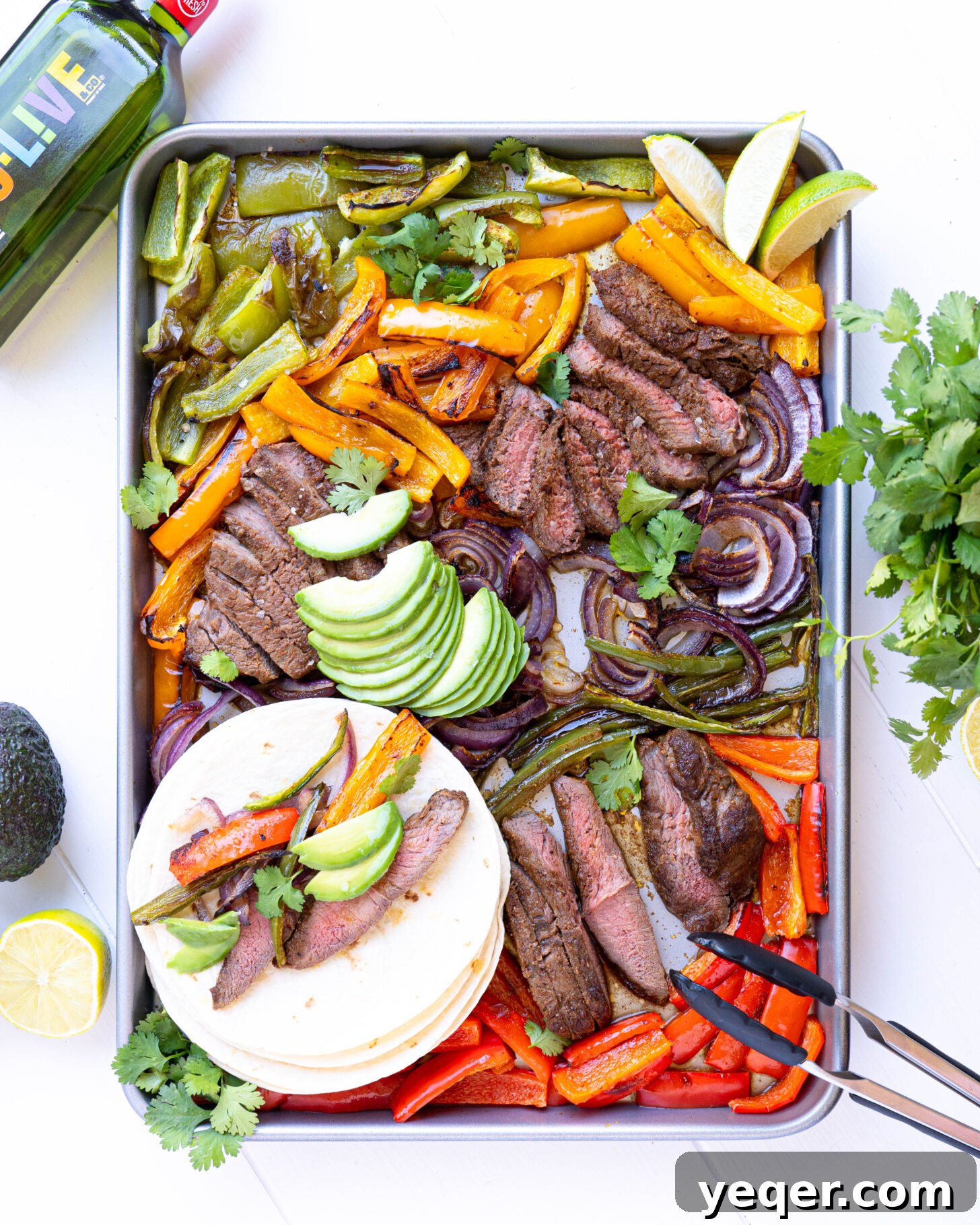 Effortless Sheet Pan Steak Fajitas 2 A vibrant sheet pan overflowing with sizzling steak fajita fixings, ready to be served.