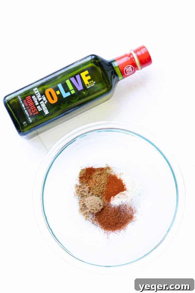 Effortless Sheet Pan Steak Fajitas 4 A bowl of vibrant fajita spice rub next to a bottle of O-Live & Co. Robust olive oil.