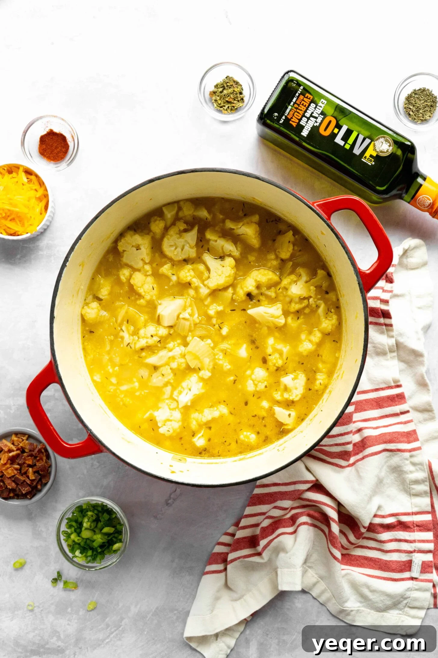 Decadent Loaded Cauliflower Dream 4 A large pot filled with boiling cauliflower florets and broth, cooking on a stove top.