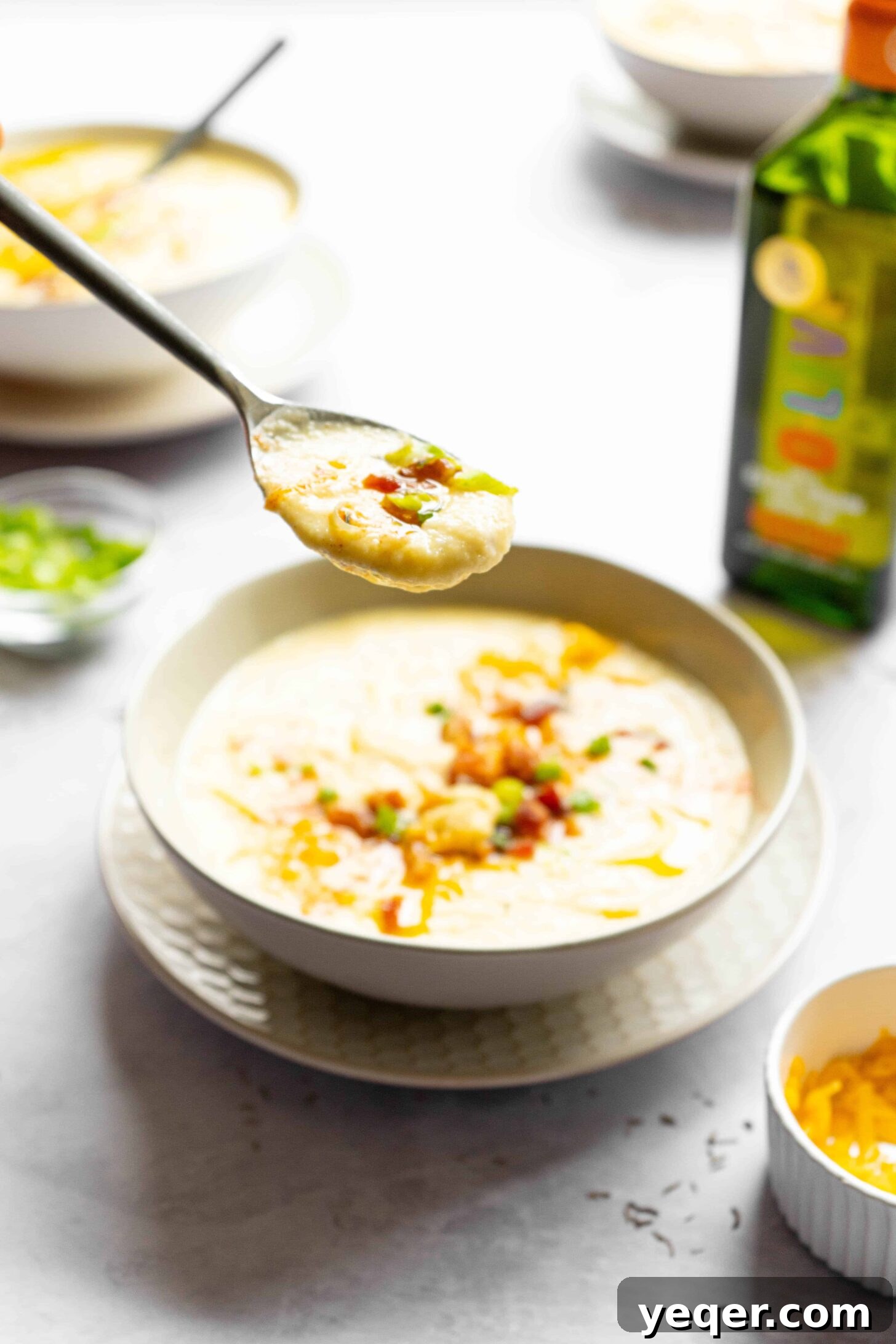 Decadent Loaded Cauliflower Dream 9 A spoon full of creamy loaded cauliflower soup, ready to be enjoyed.