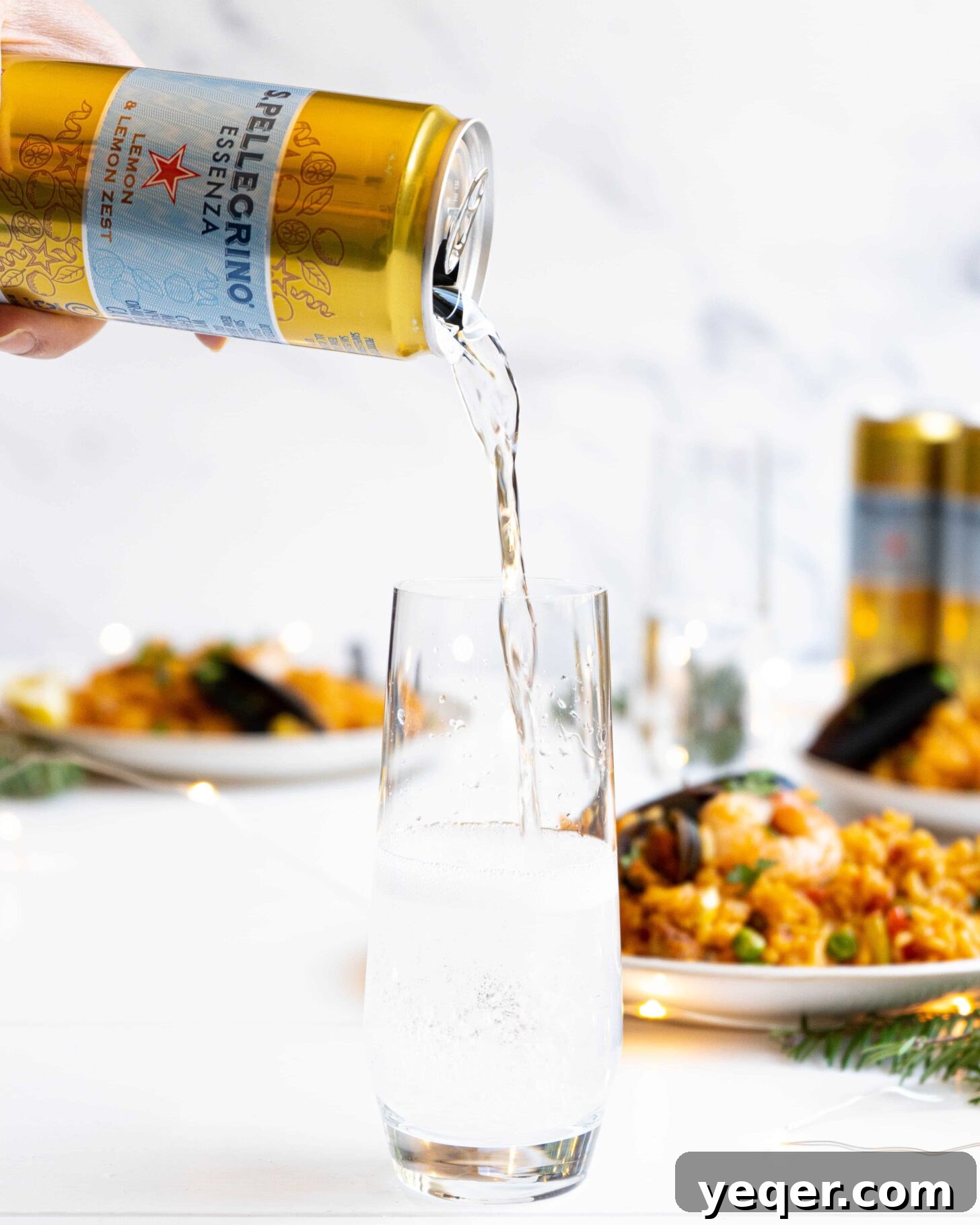 Golden Saffron Shrimp Paella 2 A can of S.Pellegrino pouring into a stemless glass amongst seafood paella