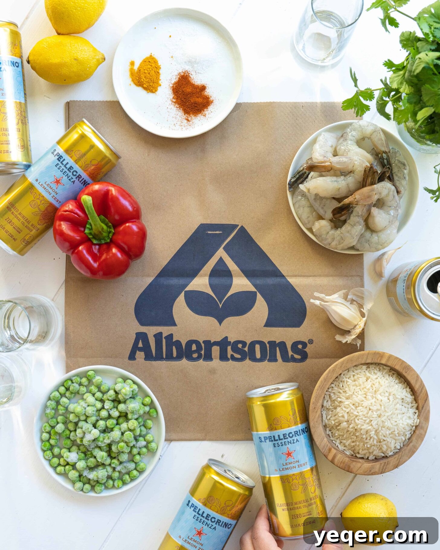 Golden Saffron Shrimp Paella 3 Ingredients on an Albertsons bag with cans of mineral water and glasses