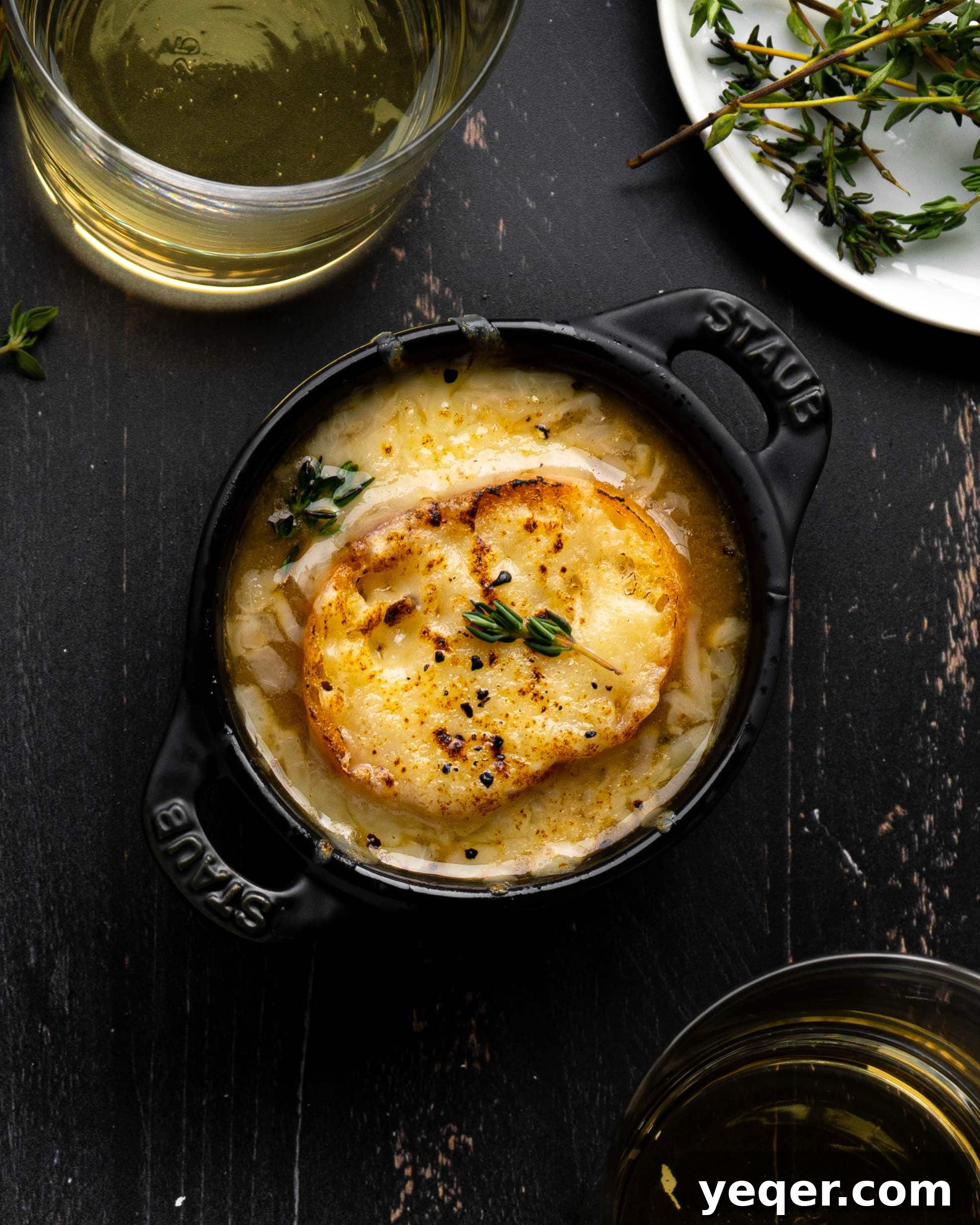 Homemade French Onion Soup Elevated with O-Live and Co 2 A bowl of French Onion Soup next to glasses of wine