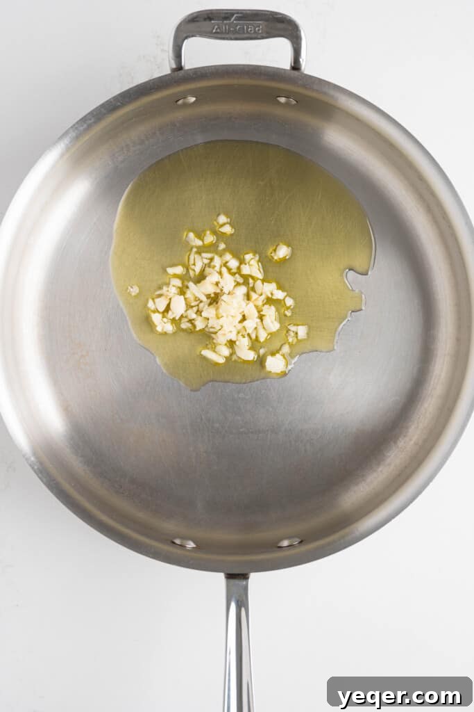 Moroccan Lentil & Herb Salad 4 Olive oil being heated in a saucepan with minced garlic, releasing fragrant aromas.