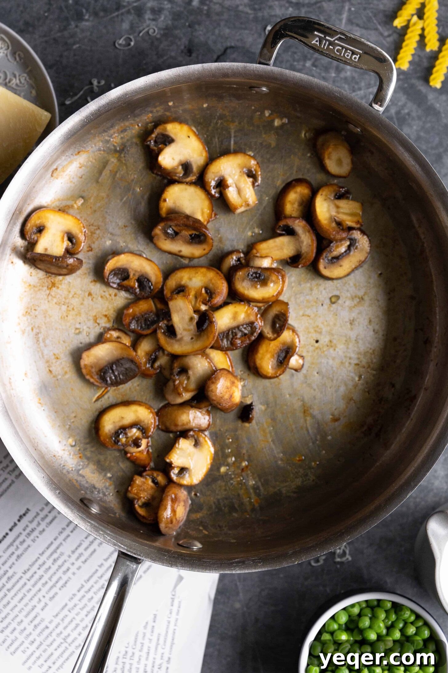 Savory Mushroom Medley Pasta 3 A close-up shot of sliced crimini mushrooms caramelizing in a pan with olive oil and butter.