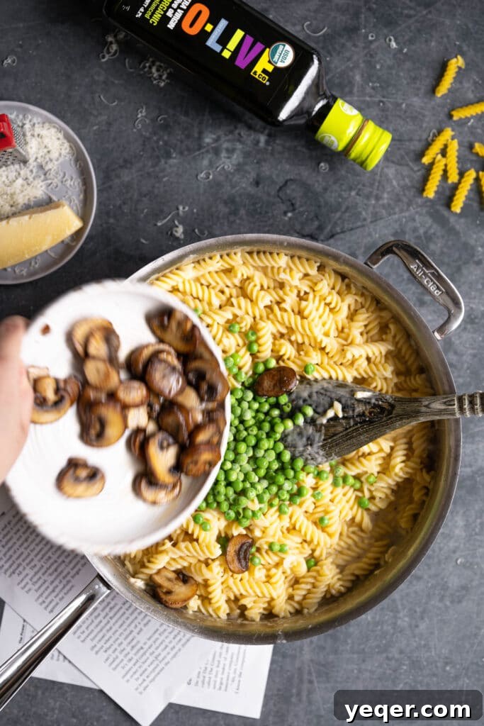 Savory Mushroom Medley Pasta 9 Caramelized mushrooms and peas being stirred into the pasta and sauce mixture.