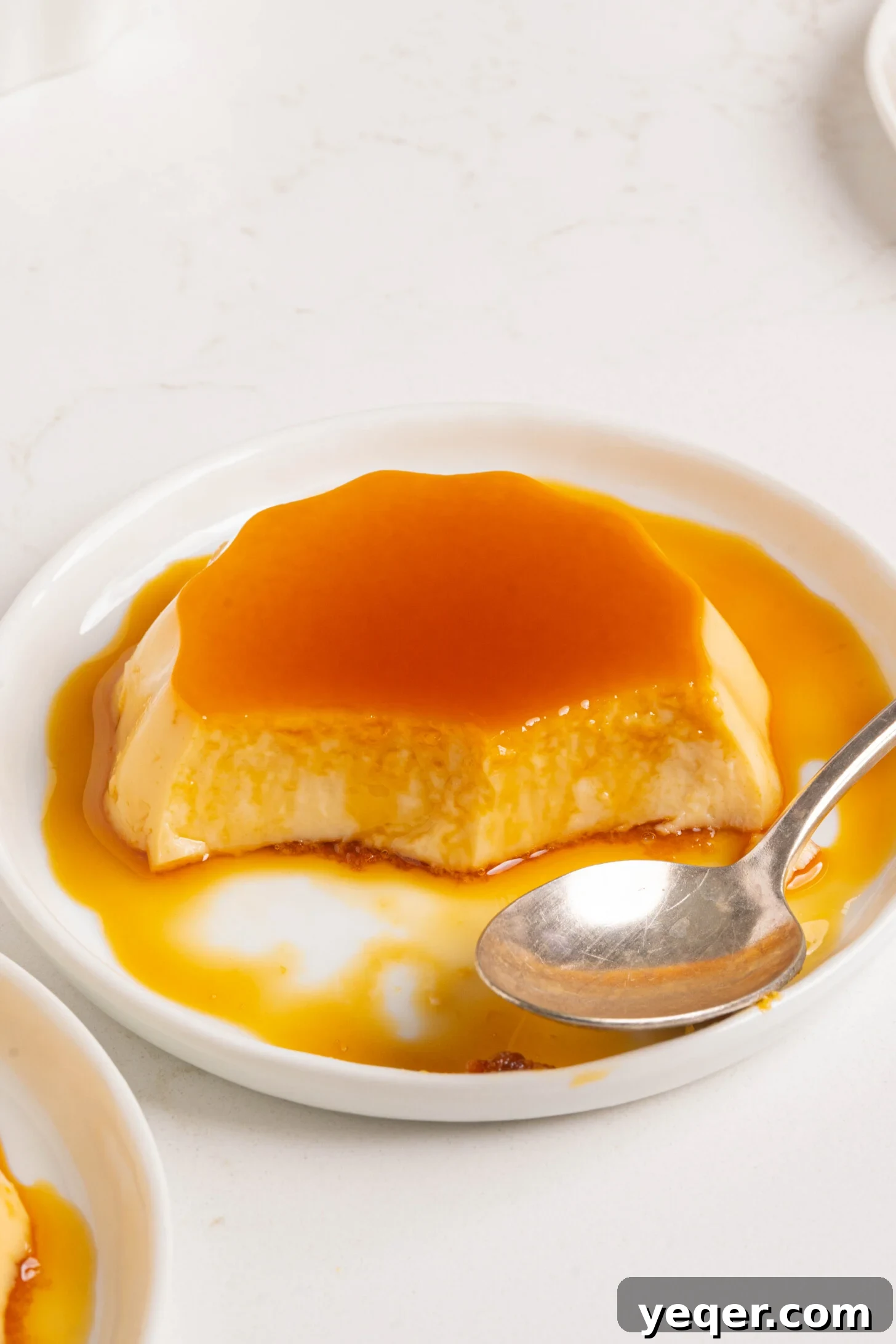Silky Puerto Rican Caramel Flan 3 A perfectly prepared Puerto Rican flan with a few slices already enjoyed, revealing its smooth custard interior and glossy caramel.