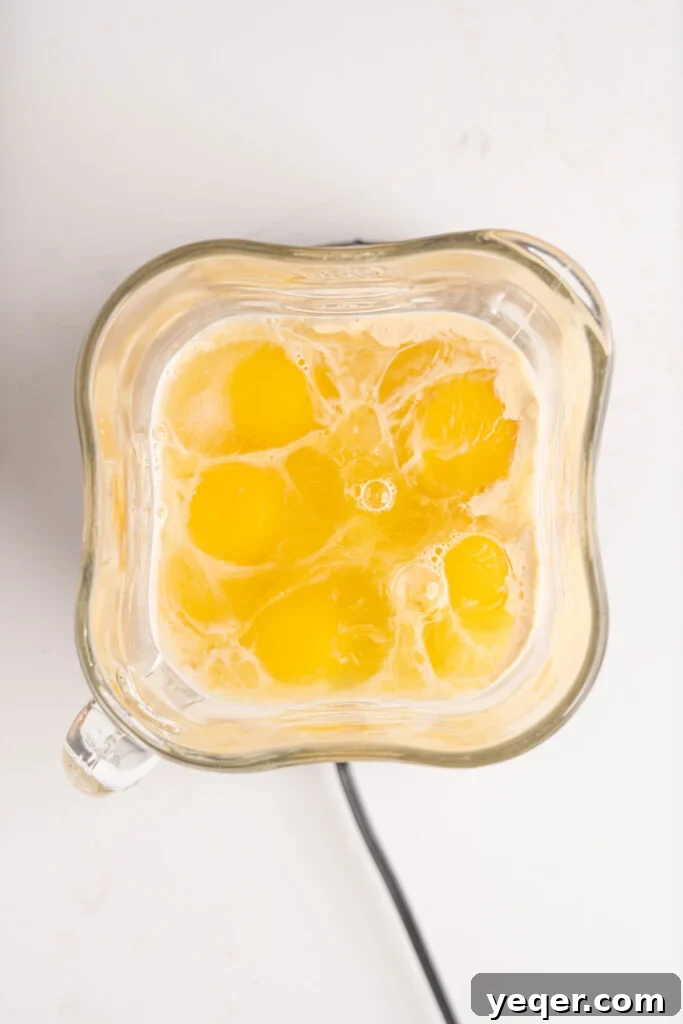 Silky Puerto Rican Caramel Flan 7 All flan custard ingredients, including milk, evaporated milk, eggs, vanilla, and sugar, in a blender.