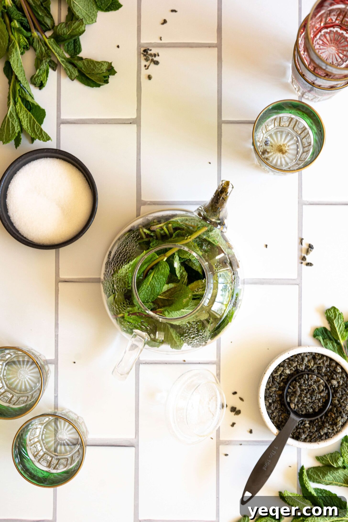 Moroccan Mint Elixir 4 Lush, fresh sprigs of mint leaves arranged inside a traditional Moroccan teapot, poised to infuse the tea with their invigorating aroma.
