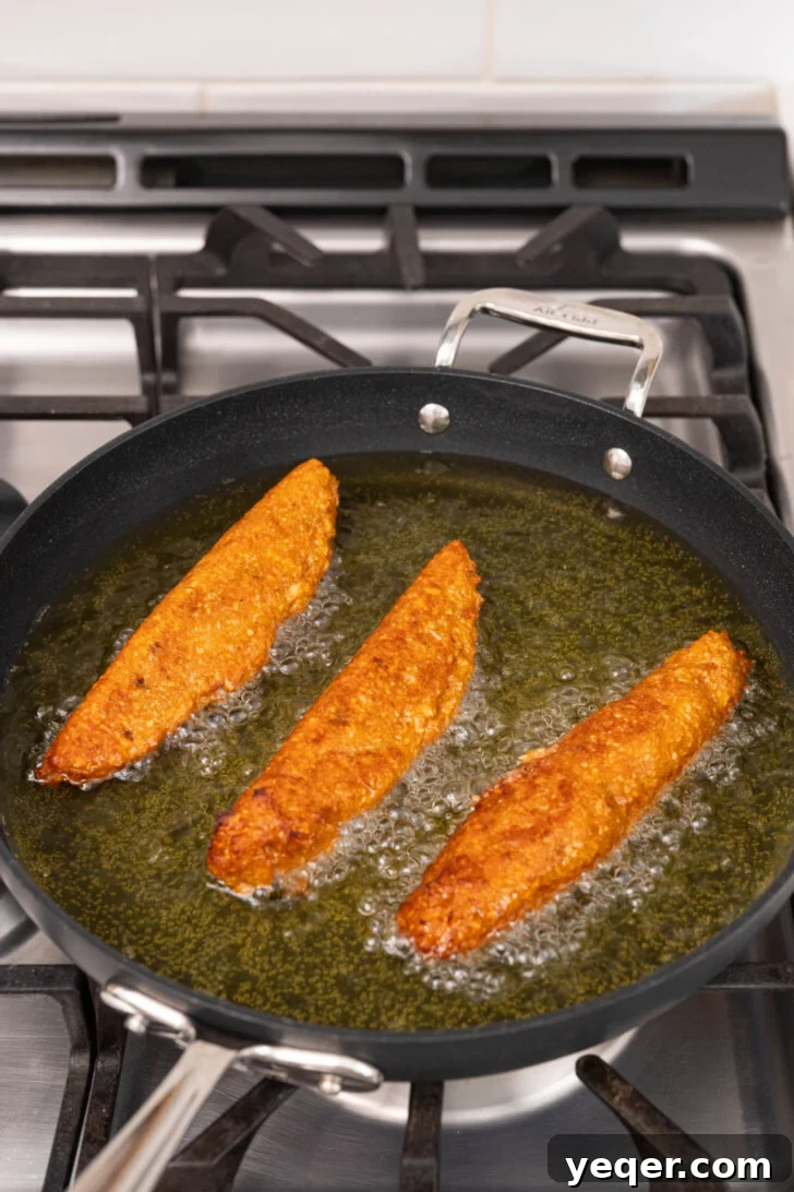 Homemade Alcapurrias: A Taste of Puerto Rico 12 Alcapurrias frying in hot oil until golden brown and crispy.
