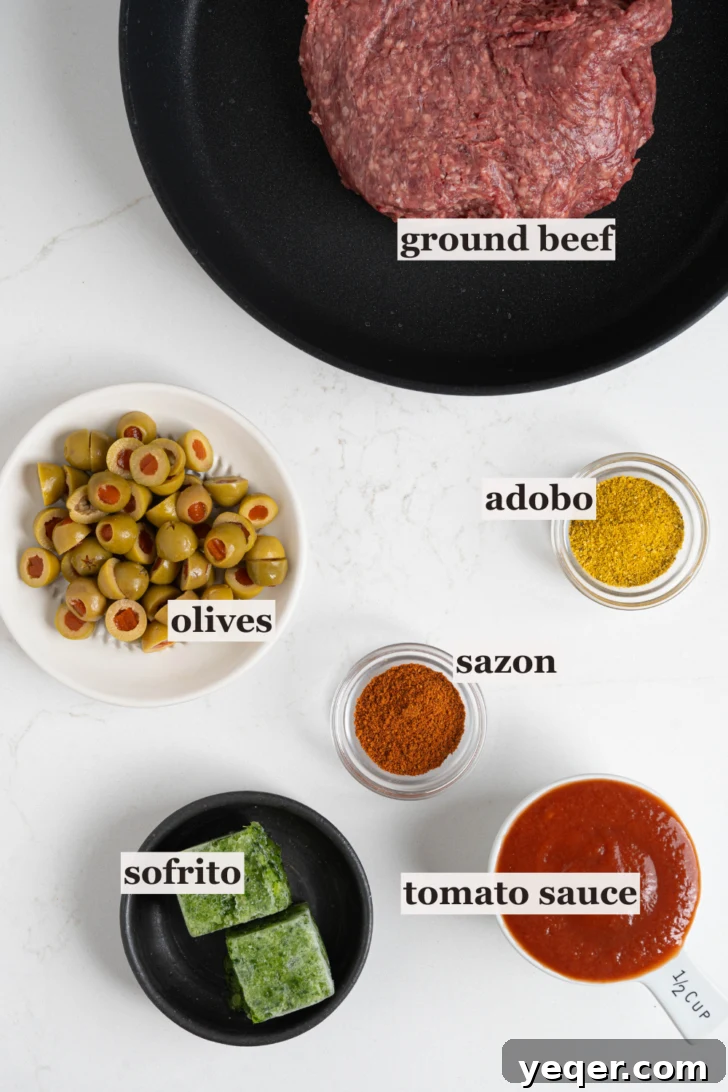 Homemade Alcapurrias: A Taste of Puerto Rico 4 Various bowls holding ingredients for picadillo filling: spices, olives, sofrito, and tomato sauce.