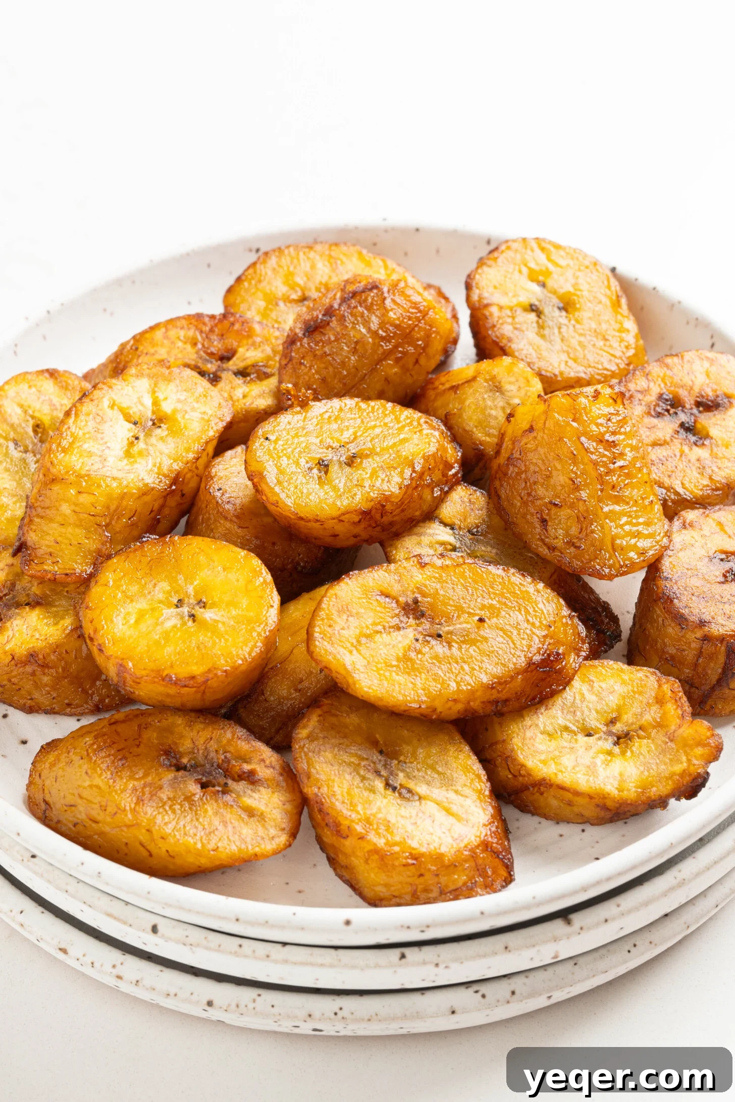 Caramelized Golden Plantains 12 A large serving bowl filled with a generous portion of sweet fried plantains.
