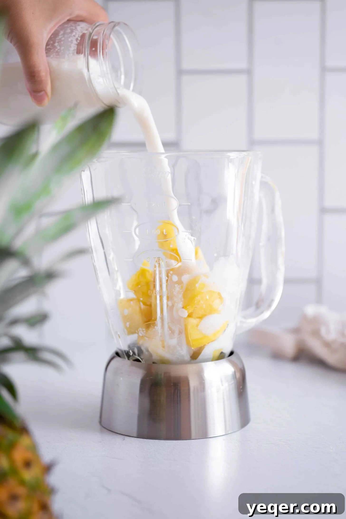 Pink Pina Perfection 3 Thick, creamy full-fat coconut milk being poured from a can into a high-powered blender, ready to be combined with other tropical ingredients to form the rich base of the Piña Colada.