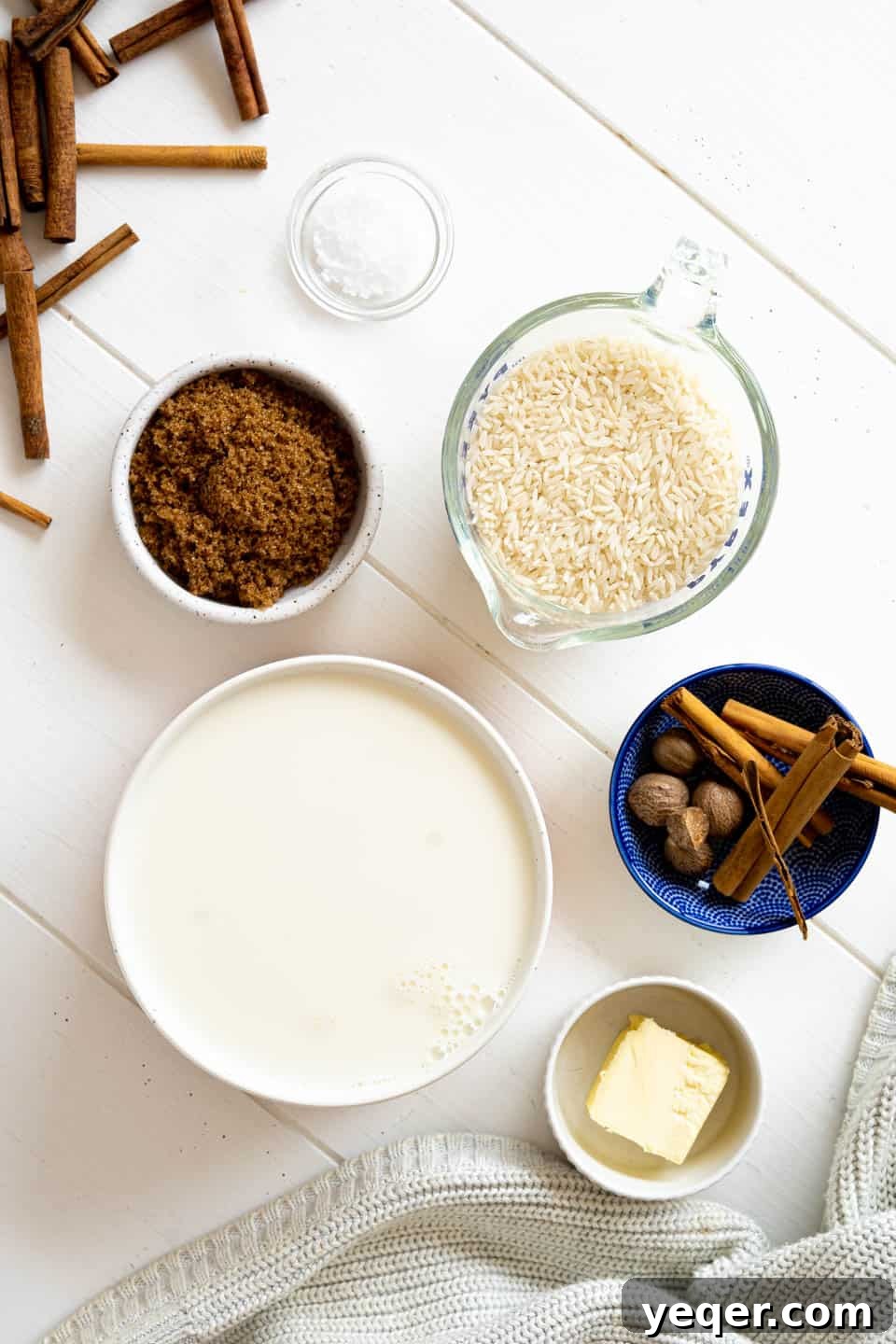 Velvety Rice Dream 3 A vibrant flat lay photo showcasing all the fresh ingredients laid out on a clean surface, ready to be combined for a delicious Arroz con Leche recipe. Includes white rice, whole milk, brown sugar, butter, and an assortment of spices like cinnamon sticks, cloves, and ground nutmeg.