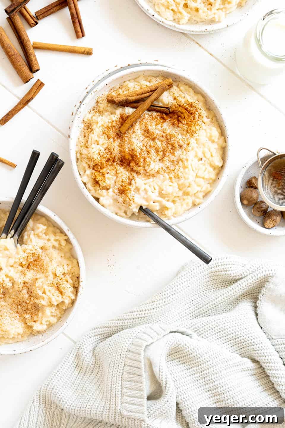 Velvety Rice Dream 8 A close-up of a rustic wooden bowl filled with creamy Puerto Rican Arroz con Leche, garnished generously with ground cinnamon and a single cinnamon stick. The texture appears rich and inviting, ready to be enjoyed as a comforting dessert.