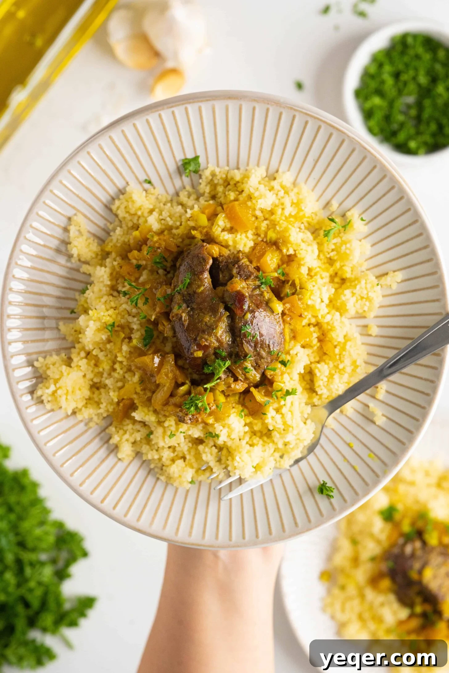 Authentic Moroccan Tangia Lamb Shank Tagine 9 A generous serving of Moroccan lamb shank tagine, elegantly garnished and ready for a meal.