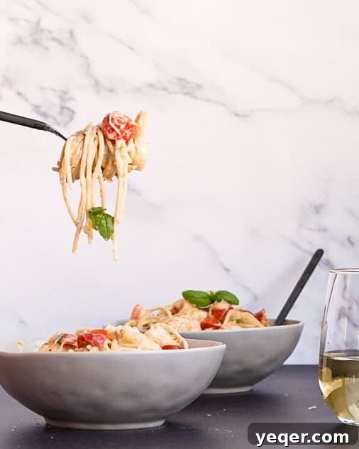Velvety Shrimp Carbonara 3 A fork twirling gluten free shrimp carbonara, showcasing the creamy sauce and fresh ingredients, next to a glass of wine.