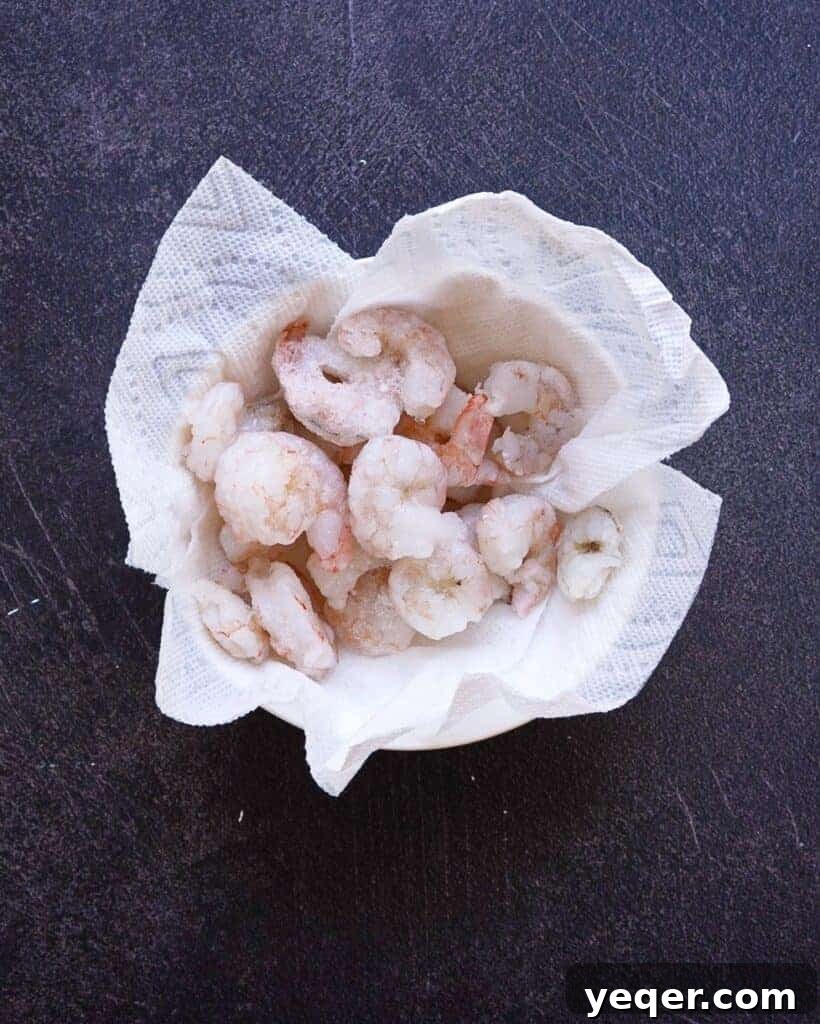 Velvety Shrimp Carbonara 4 A bowl of fresh, raw shrimp on a paper towel, ready for preparation.