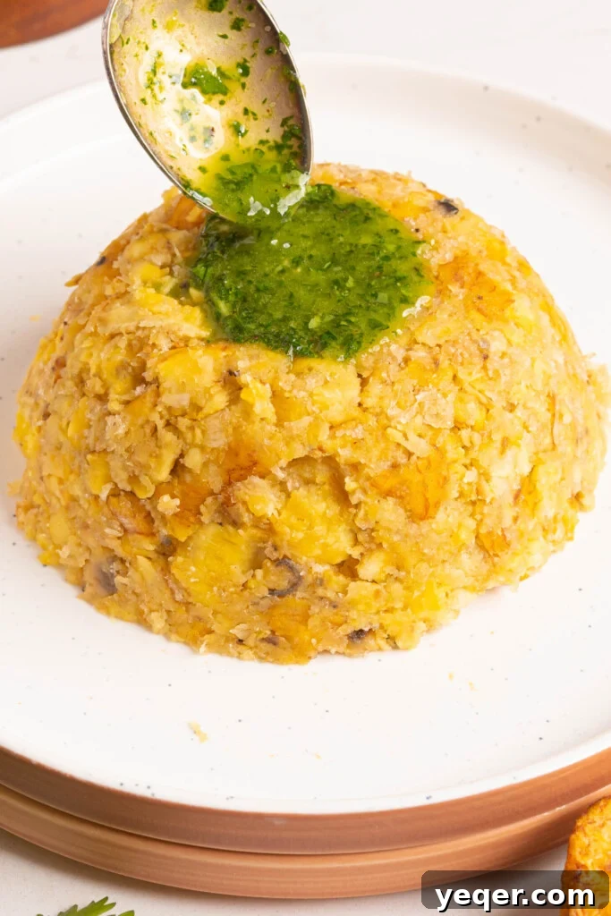25 Dakikada Geleneksel Porto Riko Mofongosu 10 A vibrant cilantro sauce being drizzled over a dome of Mofongo, adding freshness and flavor.