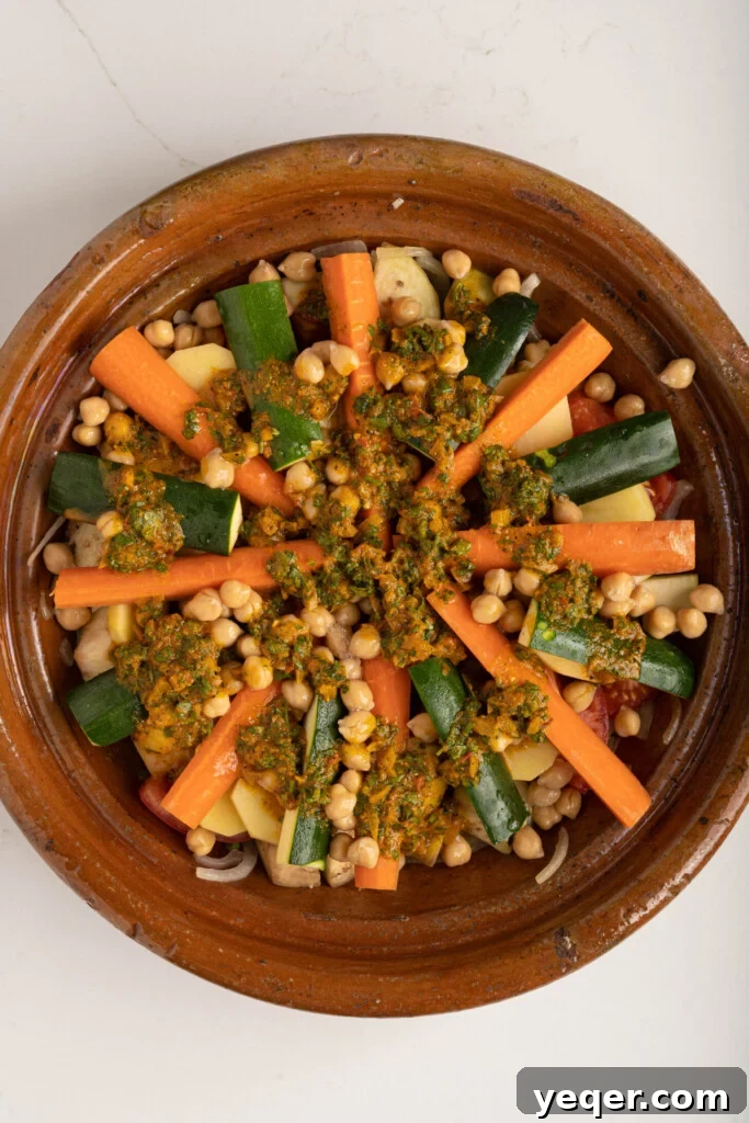 Spiced Moroccan Potato and Vegetable Tagine 12 A traditional Moroccan tagine pot, covered with its distinctive conical lid, ready to be placed in the oven for slow, even cooking, ensuring tender vegetables and a rich, aromatic sauce.