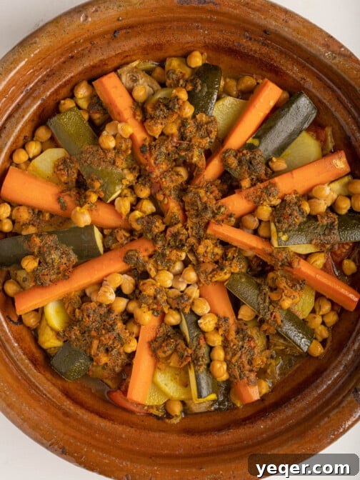A Moroccan vegetable tagine, freshly prepared and steaming, showcasing its rich colors and textures, ready to be served from a traditional pot.