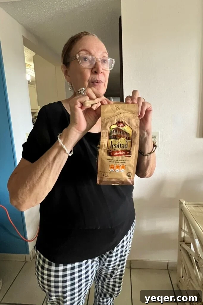 A woman smiling and holding a bag of Lealtad brand Puerto Rican coffee.