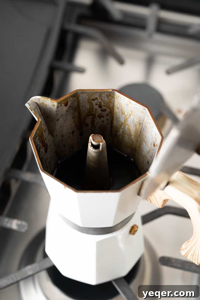 Freshly brewed Puerto Rican coffee in a Moka pot, demonstrating the first step in making Café con Leche.