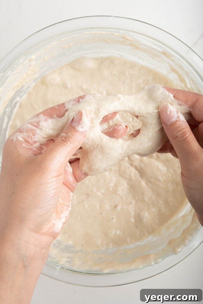 Sfenj: Moroccan Spongy Delights 7 Hands meticulously forming a donut shape from the sticky dough by poking a hole through the center.