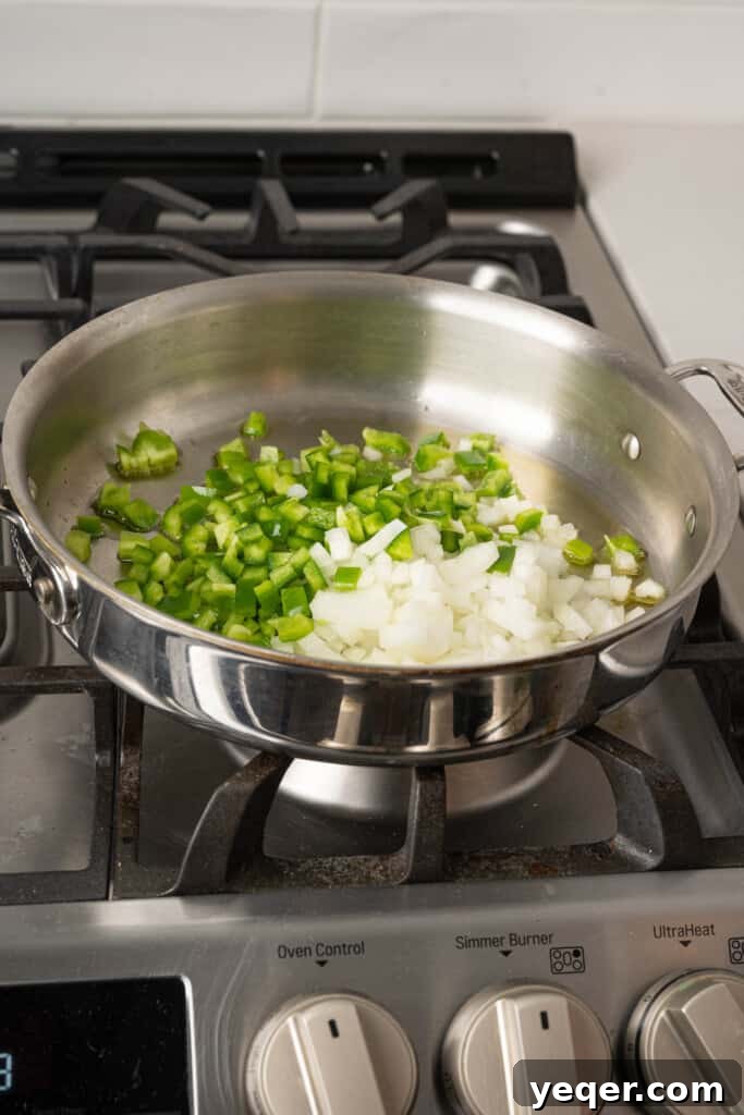 Savory Simmered Shrimp 4 Onions and green bell peppers sautéing in olive oil in a large pot.