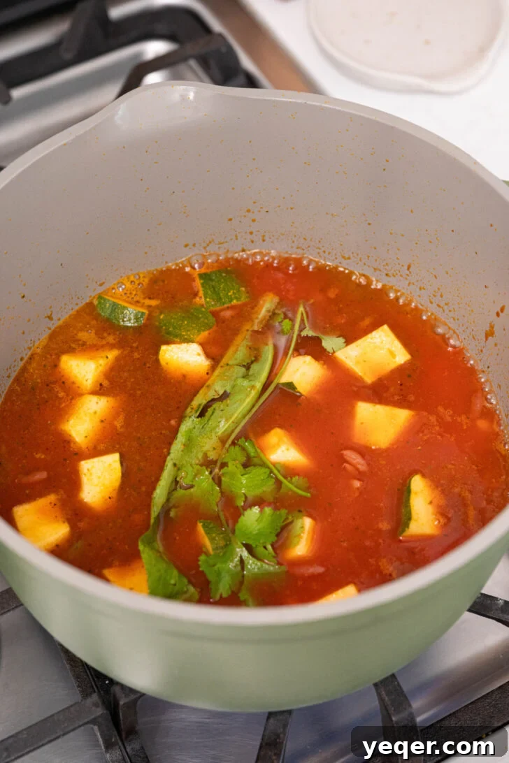 Hearty Puerto Rican Bean Stew 7 Habichuelas Guisadas simmering gently in a covered pot on low heat, allowing the flavors to meld and the broth to thicken to a perfect consistency.