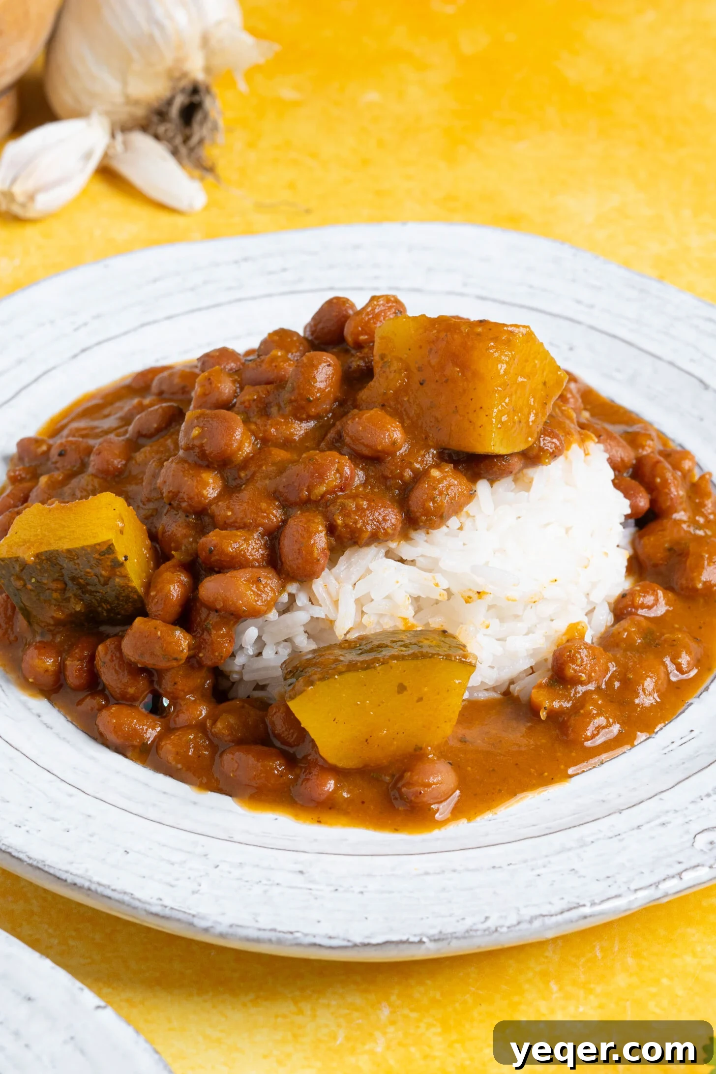 Hearty Puerto Rican Bean Stew 10 A perfectly plated serving of Habichuelas Guisadas and white rice, ready to be enjoyed as a wholesome and satisfying meal, garnished with fresh herbs.