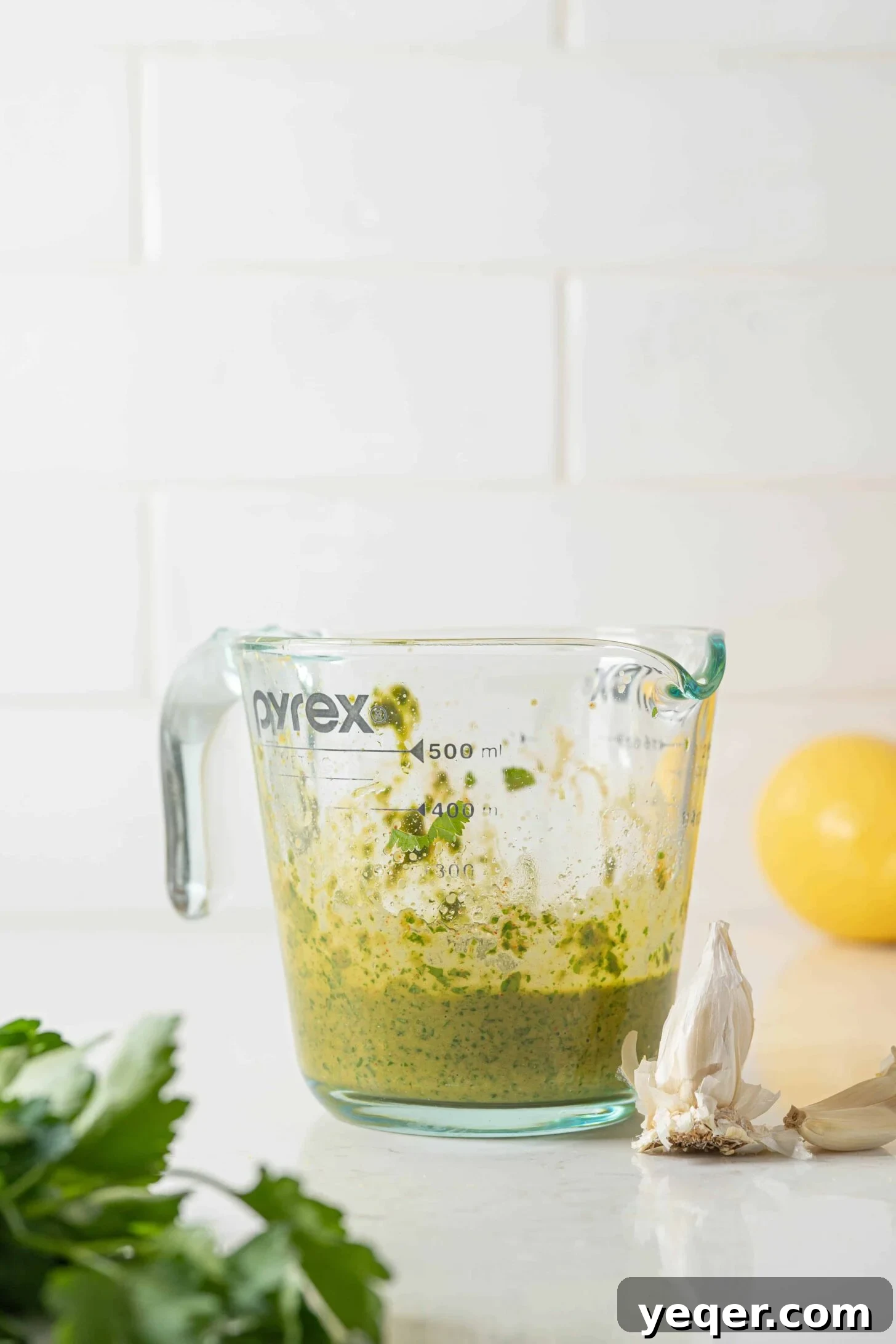 Smooth, blended chermoula marinade captured in a clear measuring cup, showing its consistent texture.