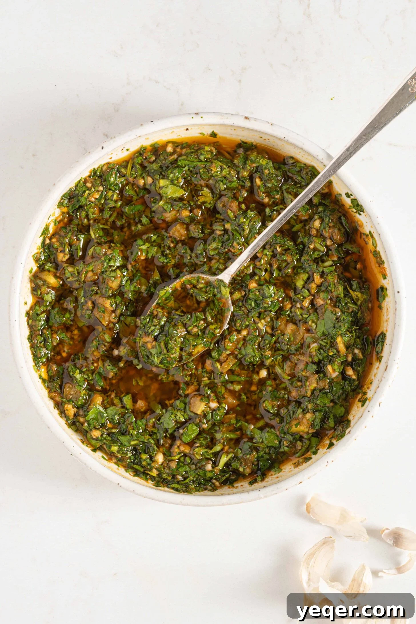 A close-up of a rustic bowl of chermoula, highlighting its rich texture and green hues.