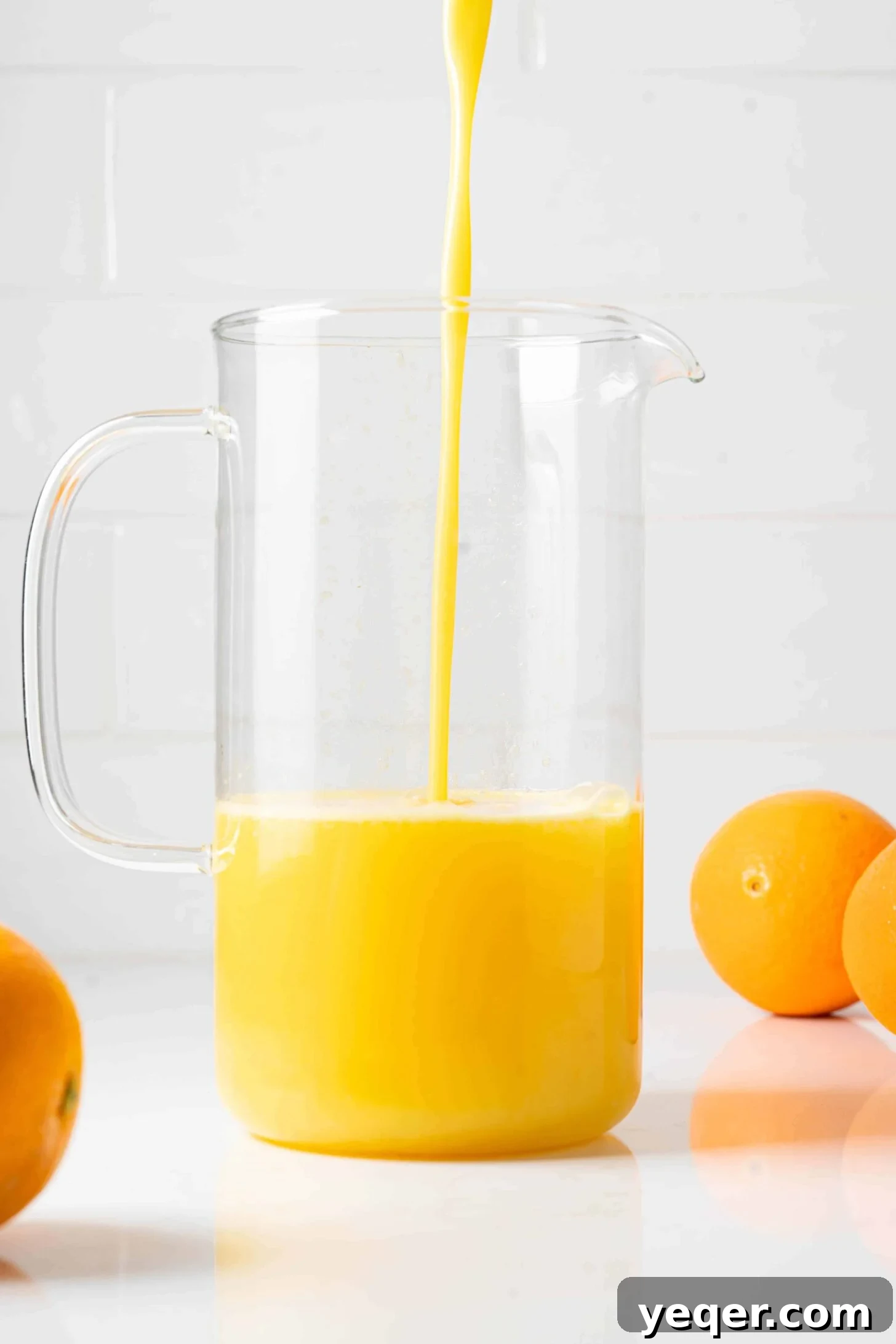 Hand-Pressed Orange Delight 9 Vibrant orange juice being poured from a traditional pitcher into a clear glass, with a backdrop of fresh oranges.