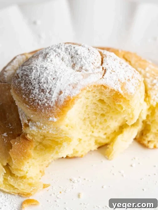 A sweet bun on a plate with a bite taken