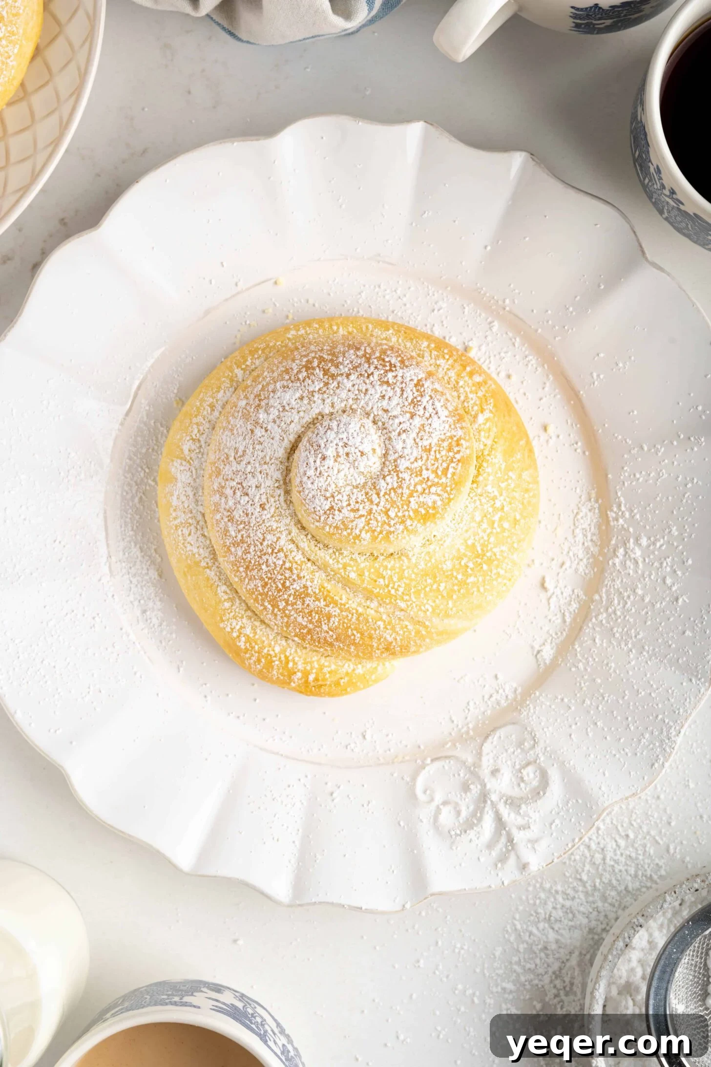 Golden Puerto Rican Sweet Mallorca 3 A close-up view of a single Pan de Mallorca roll, showcasing its perfect golden-brown crust and spiral design.