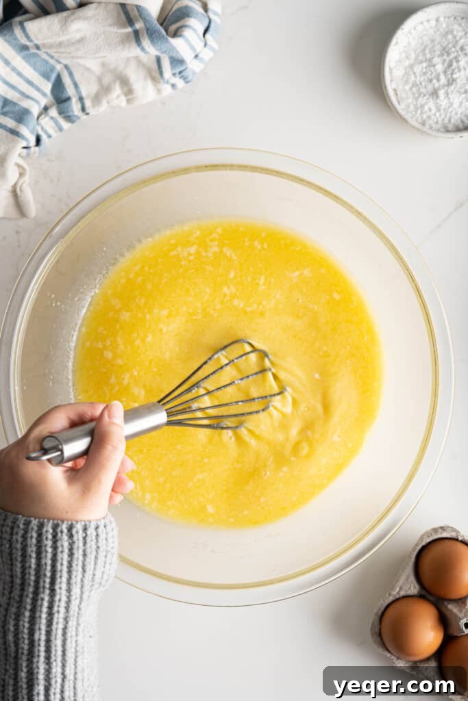 Golden Puerto Rican Sweet Mallorca 6 Wet ingredients including milk, egg yolks, sugar, and melted butter being whisked into the proofed yeast mixture.