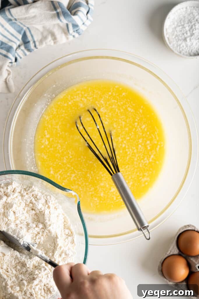 Golden Puerto Rican Sweet Mallorca 7 Dry ingredients (bread flour and salt) being gradually mixed into the wet ingredients to form a dough.