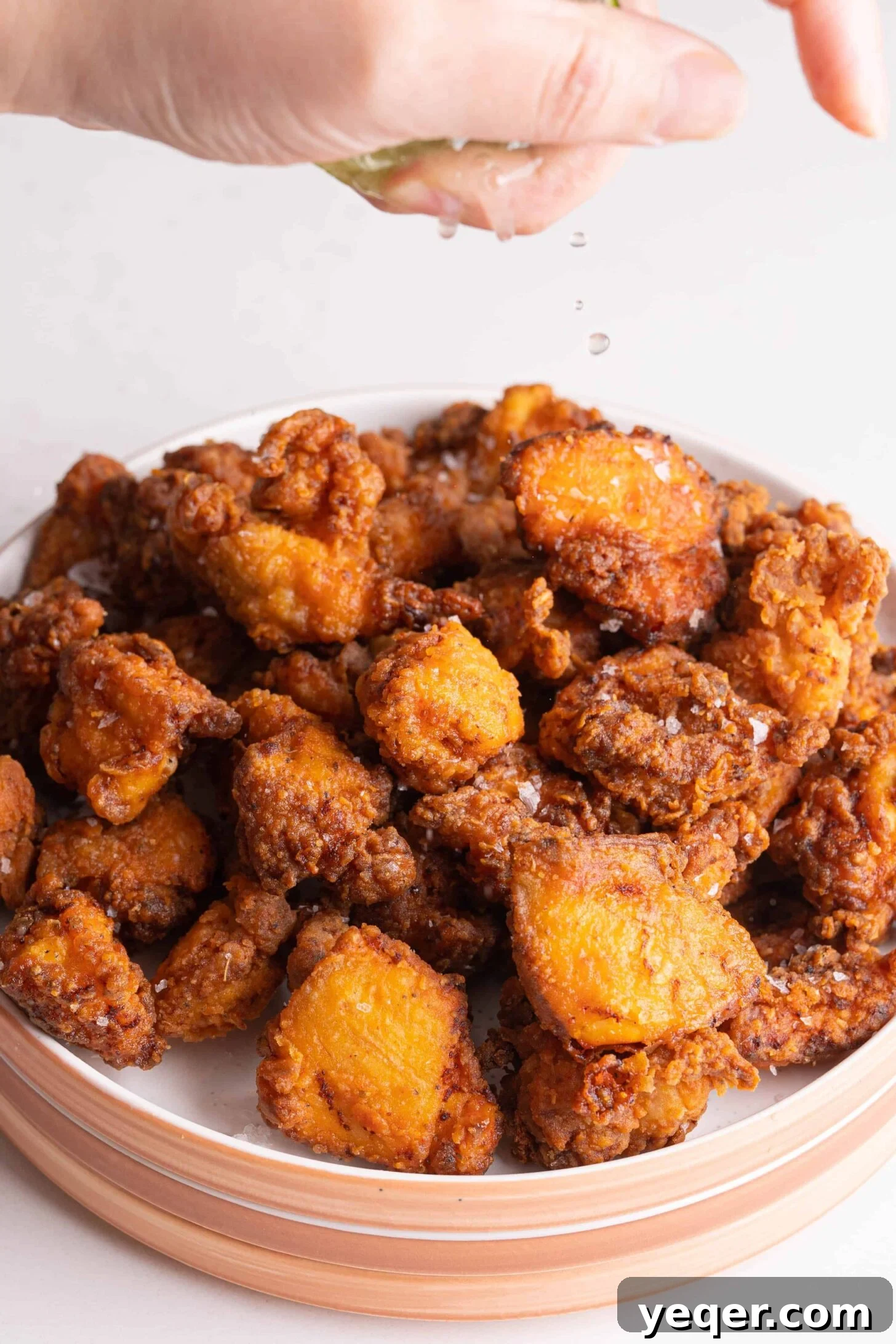 Golden Puerto Rican Chicken Chicharrones 8 Fresh lime being squeezed over crispy Puerto Rican fried chicken