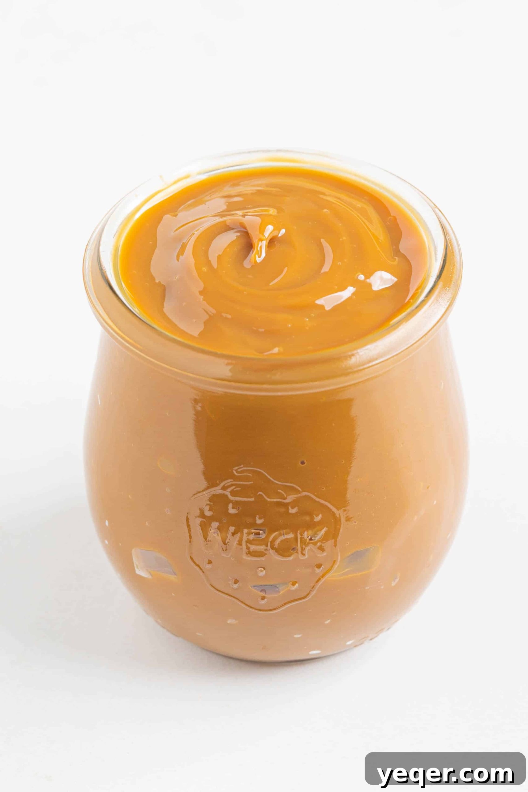 One Ingredient Wonder: Homemade Dulce de Leche Caramel Sauce 6 Close-up of creamy dulce de leche in a glass jar, highlighting its smooth texture and golden hue.