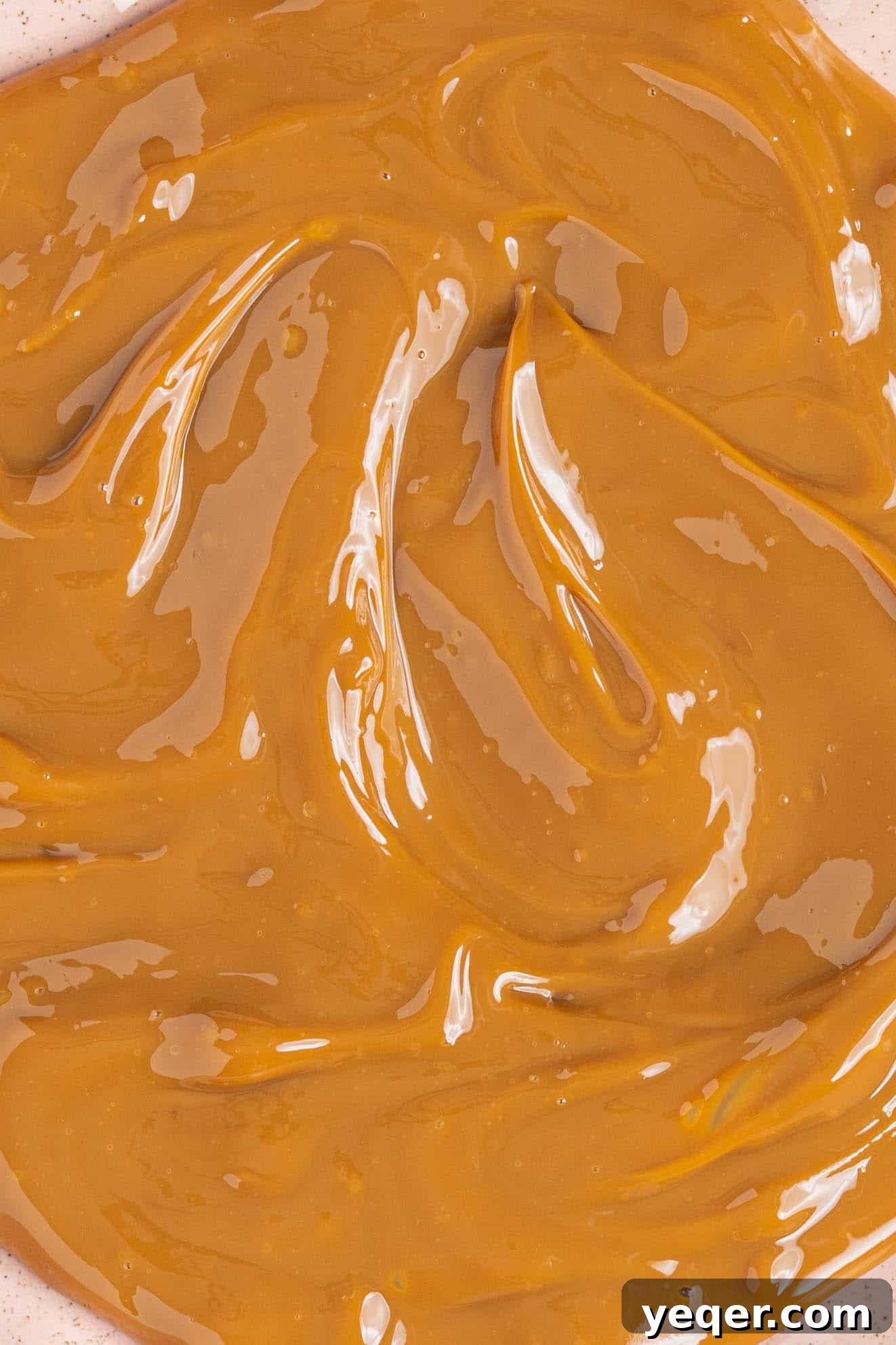 One Ingredient Wonder: Homemade Dulce de Leche Caramel Sauce 9 A close-up shot of dulce de leche artfully spread on a plate, showcasing its beautiful texture.