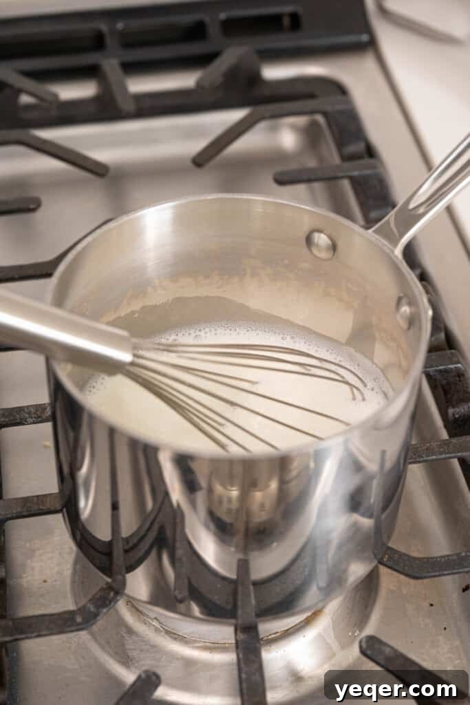 Velvety Spanish Cocoa Indulgence 5 A saucepan on a stovetop with milk being gently heated, showing a slight simmer