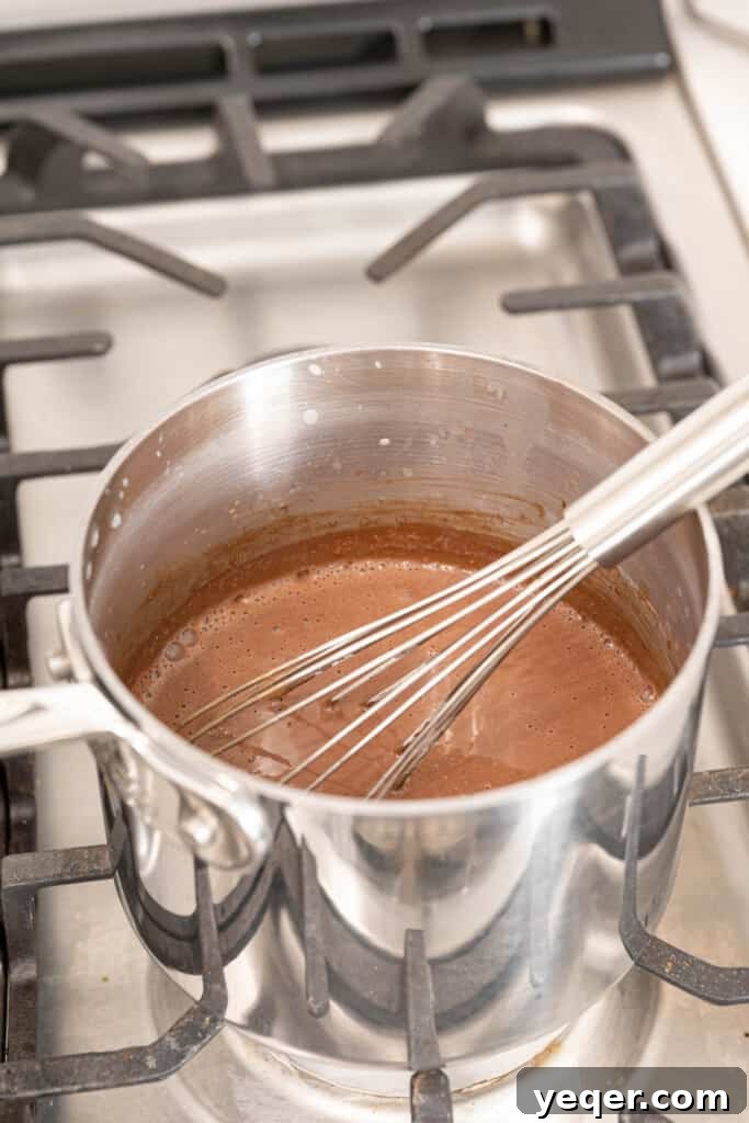 Velvety Spanish Cocoa Indulgence 6 A pot of Spanish hot chocolate on the stovetop, with melted chocolate and milk being whisked