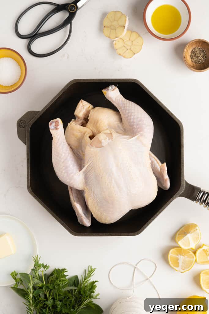 Succulent Golden Roast Chicken 3 A raw whole chicken, patted dry, positioned in a dutch oven ready for seasoning.