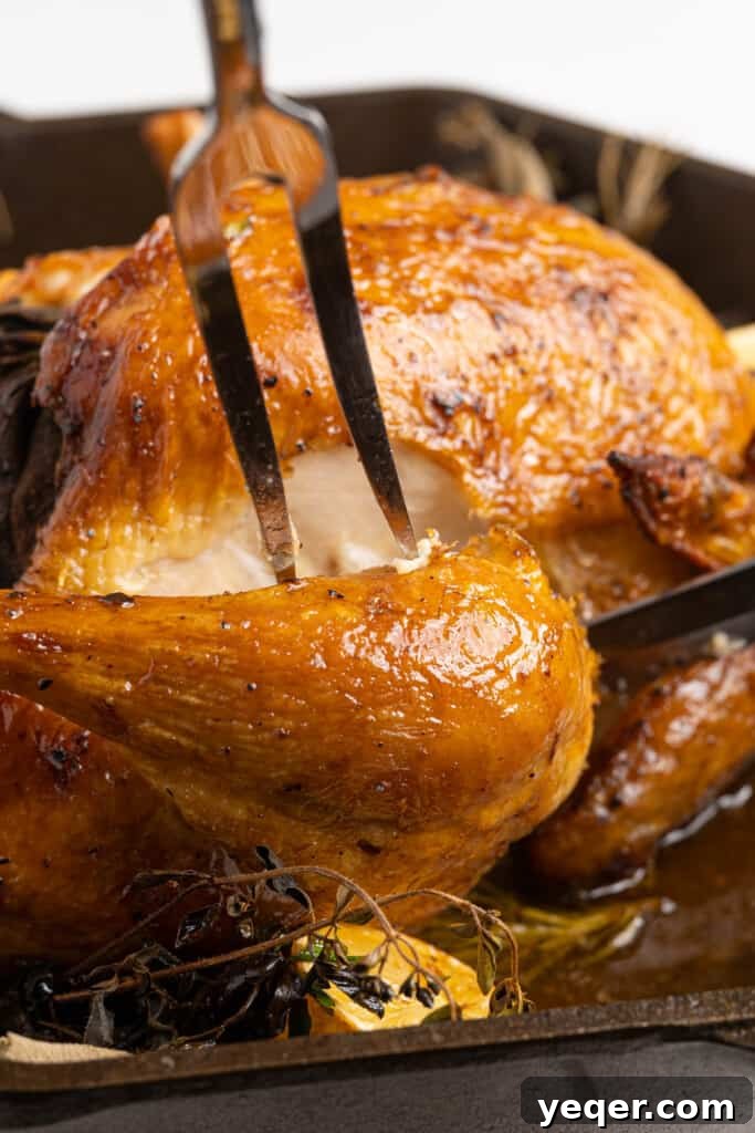 Succulent Golden Roast Chicken 5 A roasted whole chicken being carved on a wooden cutting board.